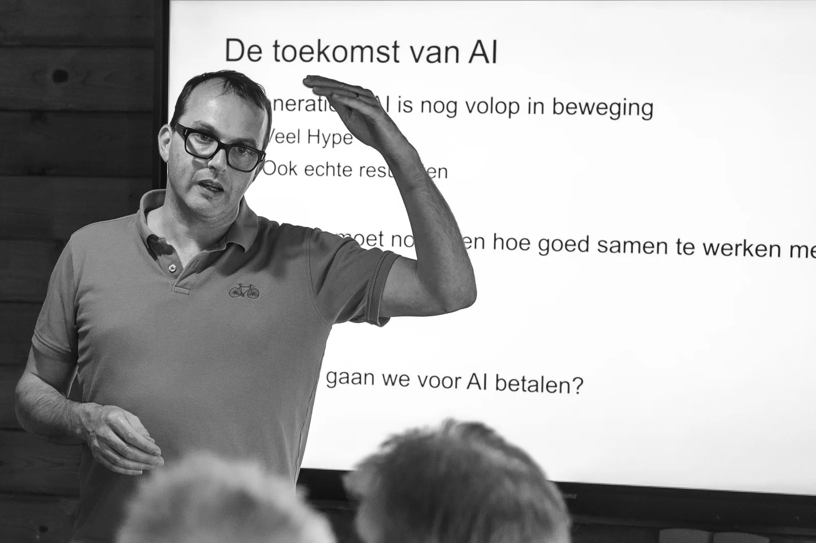 Lars Zwanepol Klinkmeijer geeft een AI-training en licht voor een groep deelnemers de slide 'De toekomst van AI' toe